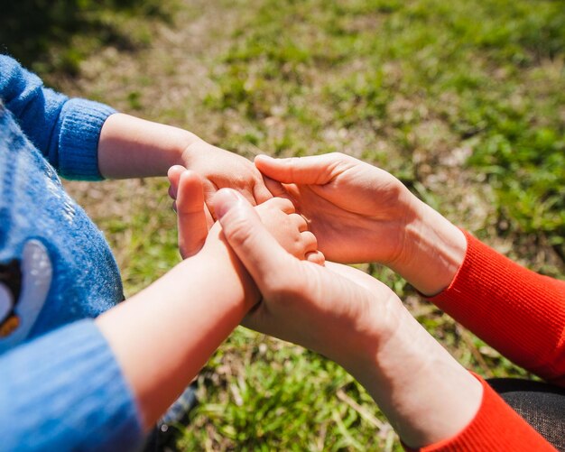 Maman tient l'enfant pour les mains