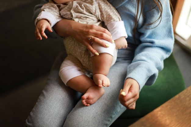 Maman tient une maman nouveau-née dans un café avec un enfant