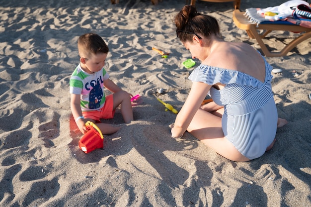 Maman en vacances avec son bébé sur la plage.