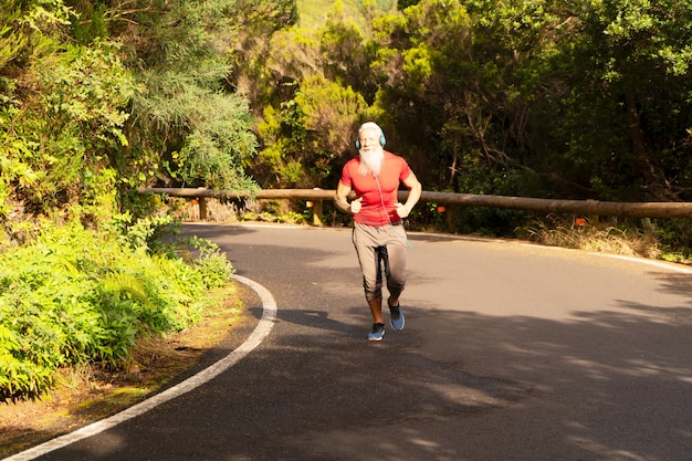 Man avec barbe blanche faisant courir en plein air sur la nature par la route