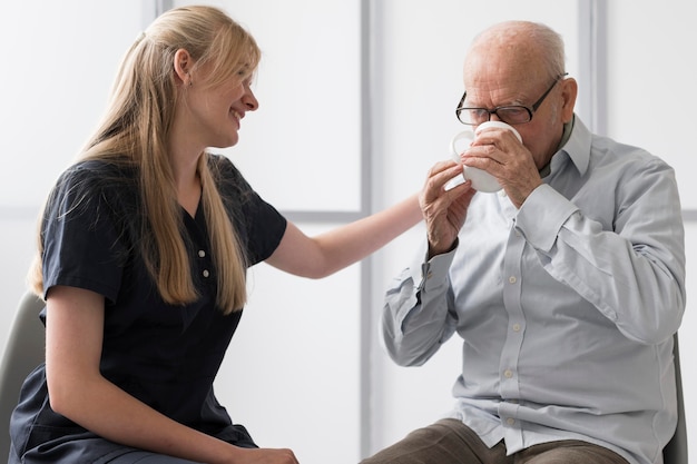 Photo man boire de l'eau avec une infirmière le consolant