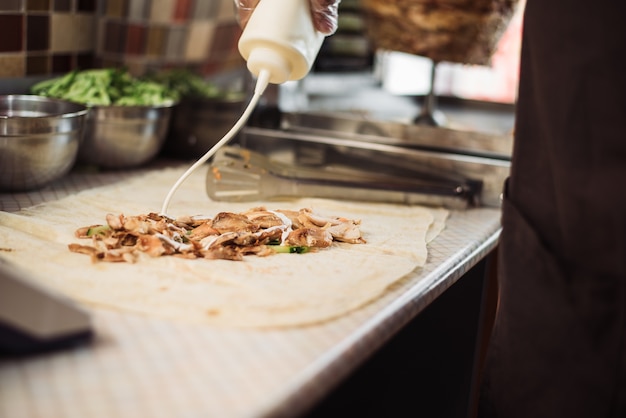 Man cooking shawarma en pita dans la cuisine