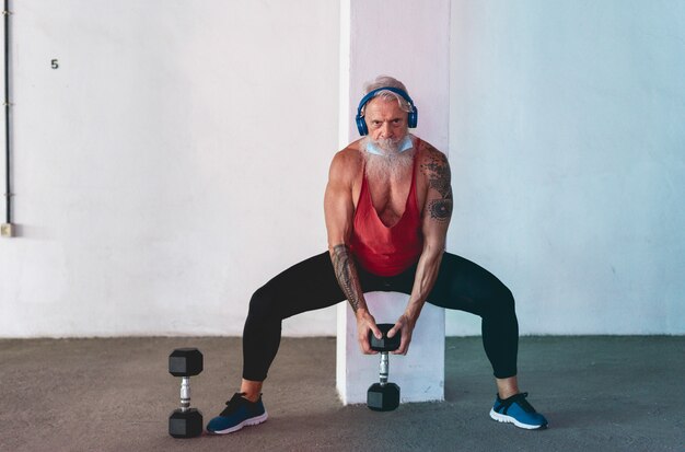 Man doing gym workout avec haltères tout en portant un masque de protection du visage