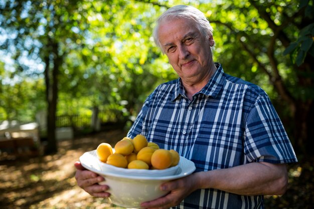 Man holding hat plein de fruits frais