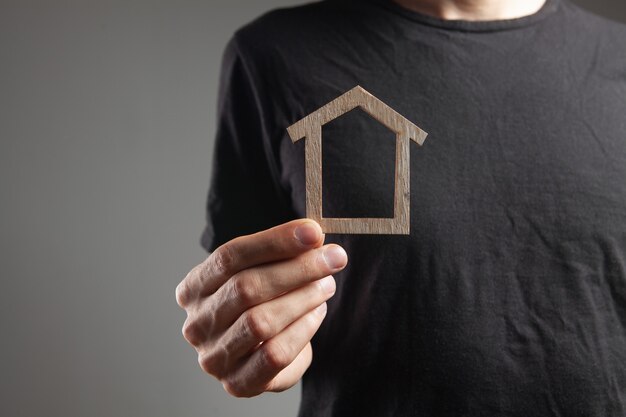 Man holding house sur fond gris