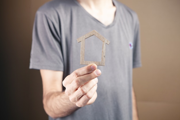 Man holding house sur fond marron