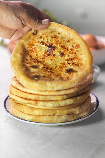 Man holding Khachapuri est du pain au fromage, cuisine traditionnelle caucasienne sur fond blanc avec des ingrédients