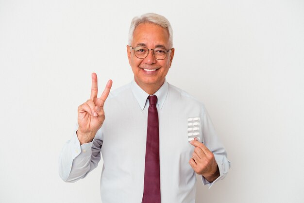 Man holding pills montrant le numéro deux avec les doigts.