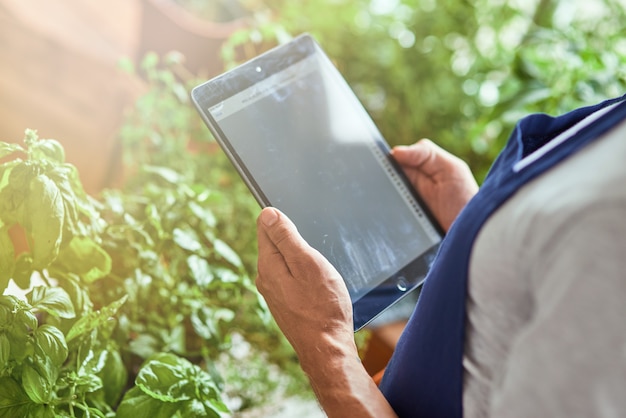 Photo man holding tablet avec écran actif en serre