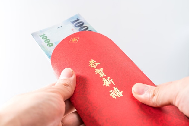 Man's hand holding avec enveloppe rouge chinoise (paquet rouge). Concept du nouvel an chinois. (Le chinois "GÅ nghÃ¨ xÄ"nxÇ" signifie "Je vous souhaite prospérité")
