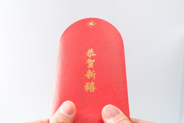 Man's hand holding avec enveloppe rouge chinoise (paquet rouge). Concept du nouvel an chinois. (Le chinois "GÅ nghÃ¨ xÄ"nxÇ" signifie "Je vous souhaite prospérité")