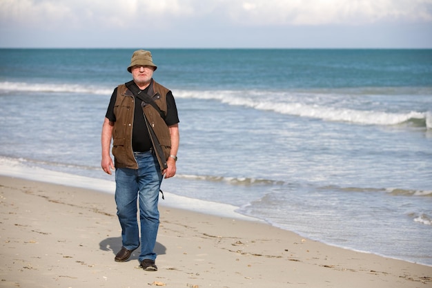 Man avec sac à dos marchant sur la plage, île de Djerba, Tunisie, Afrique