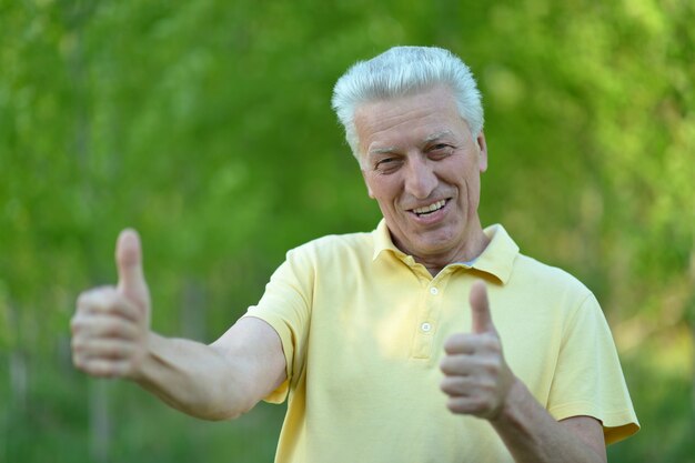 Man showing Thumbs up debout sur fond d'été n