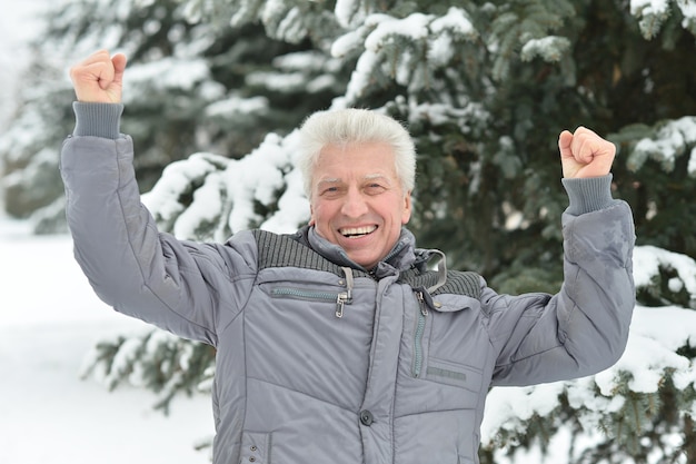 Man standing outdoor en hiver avec les mains vers le haut