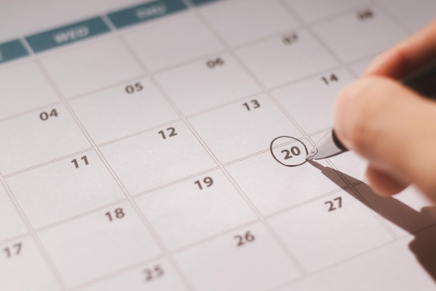 Management et ressources humaines Concept Homme d'affaires Homme de temps Marquer des cercles À l'aide d'un stylo sur les dates du calendrier Efficiemment Organisez votre travail de manière systématique