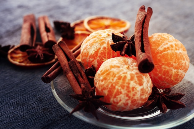 Mandarine, bâtons de cannelle et anis sur une assiette