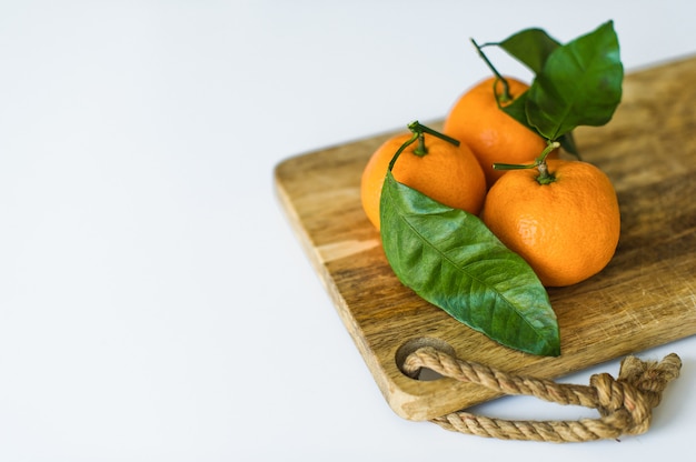 Mandarine avec des branches sur un fond blanc.