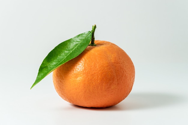 Mandarine ou clémentine avec feuille verte isolée sur surface blanche