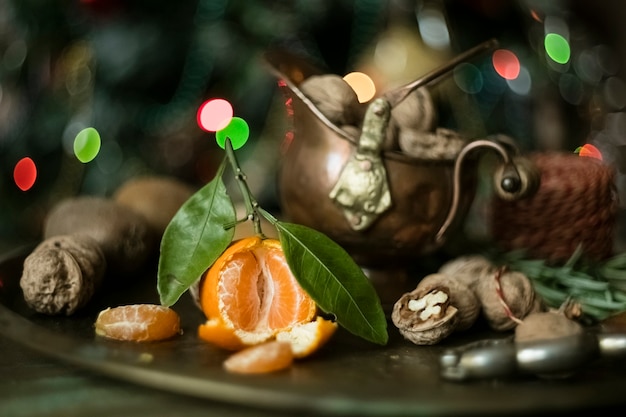 Mandarine avec des feuilles sur un plateau avec des noix