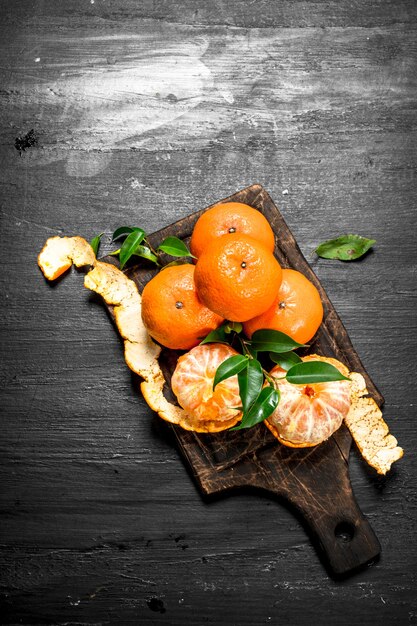 Mandarine fraîche avec des feuilles. Sur le tableau noir.