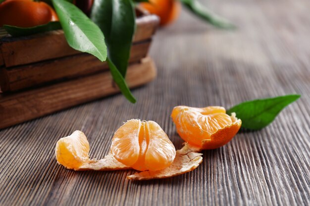 Mandarine fraîche pelée sur table en bois, gros plan