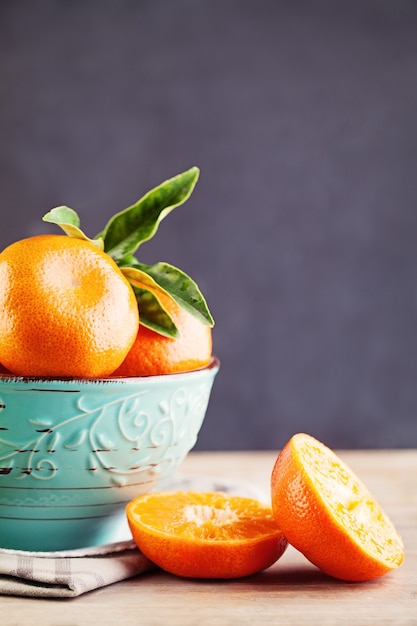 Mandarine ou Mandarine Fruits dans un bol bleu sur fond de tableau noir