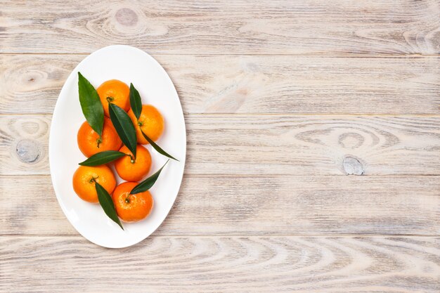 Mandarine mûre avec des feuilles, orange mandarine sur fond de table en bois avec espace de copie