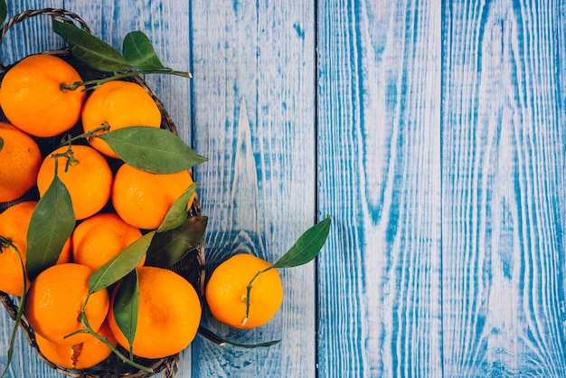 Mandarine mûre pelée ouverte et place sur de vieux bois d'aspect rustique avec groupe de fruits mandarines et laisse floue sur la surface