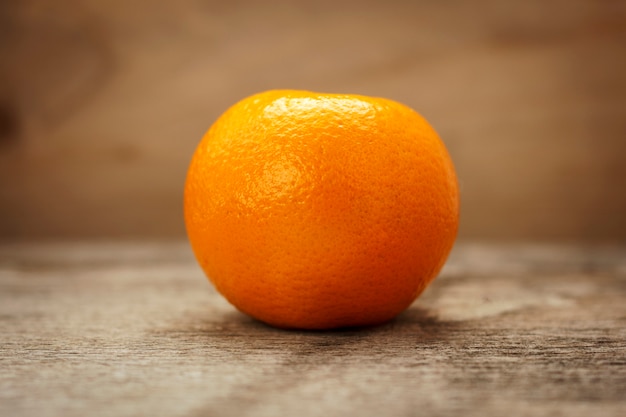 Mandarine mûre sur une table en bois sur un fond marron