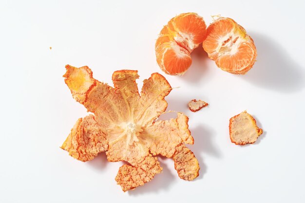 Mandarine pelée avec peau sur fond blanc