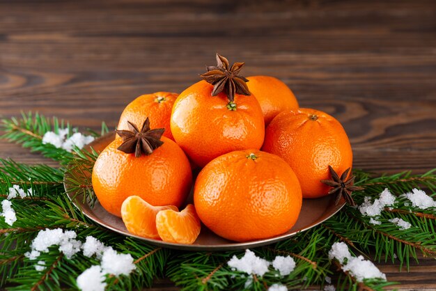 Mandarines à l'anis sur une assiette avec des branches d'épinette