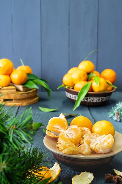 mandarines sur une assiette tranches d'agrumes sur un fond en bois arbre et feuilles vertes