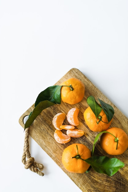 Mandarines avec des branches sur un fond blanc.