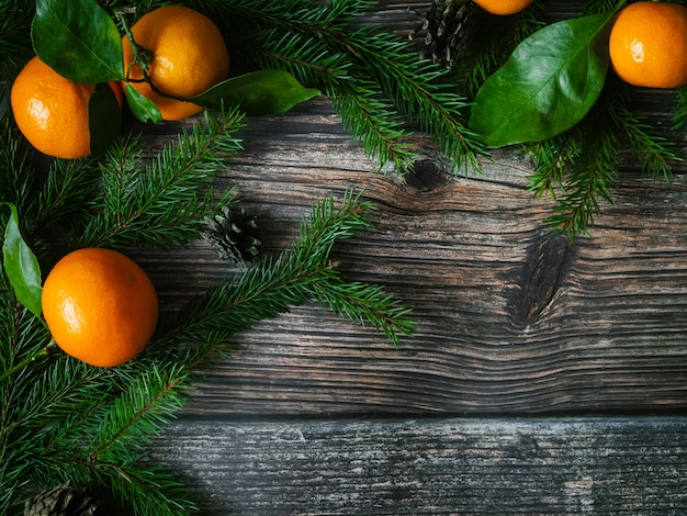 Mandarines et branches de sapin sur un fond en bois pour les vacances de Noël