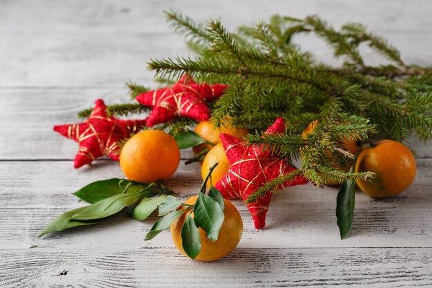 Mandarines, brunchs de sapin, pommes de pin et noix. Décorations alimentaires de Noël. Réglage de la table.