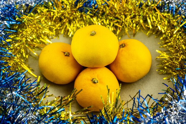 Les mandarines du Nouvel An décorées de guirlandes. Décoration de Noël et du nouvel an.