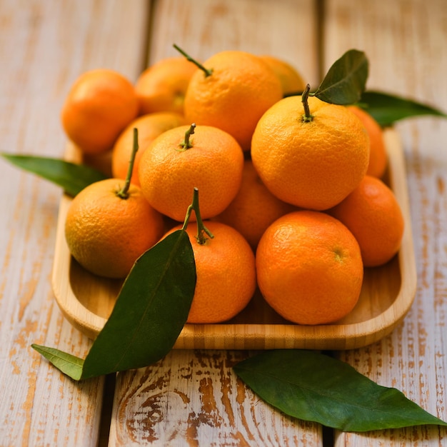 Mandarines avec des feuilles sur un fond en bois rustique