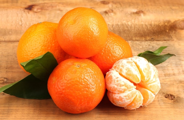 Mandarines avec feuilles sur table en bois