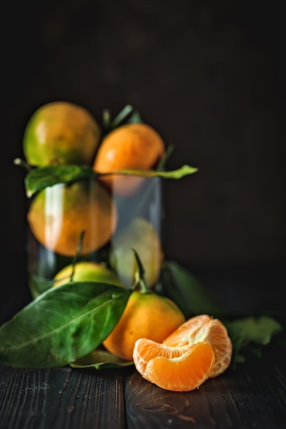Mandarines avec des feuilles sur une table de pays à l'ancienne