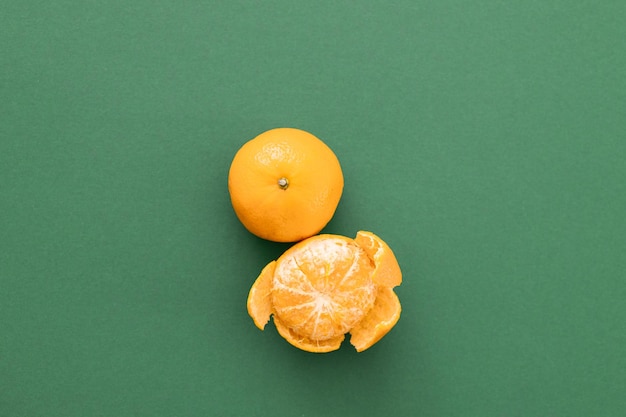 Mandarines avec feuilles et tranches sur fond vert