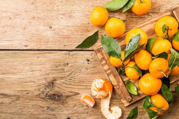 Mandarines avec des feuilles sur de vieux bois. Vue de dessus.