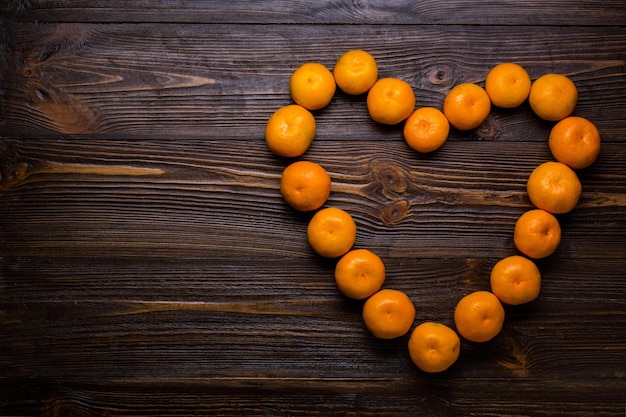 Mandarines en forme de coeurs sur fond de bois avec espace de copie