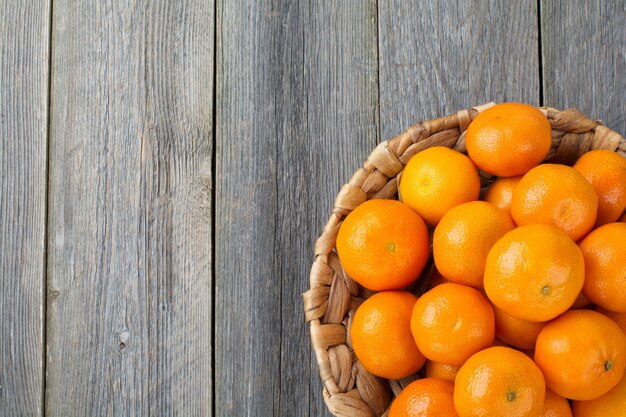 Mandarines fraîches sur une assiette en rotin. Vue de dessus. Style rustique. Mise au point sélective.