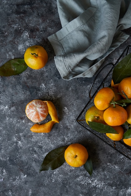 Mandarines juteuses avec des feuilles dans un panier