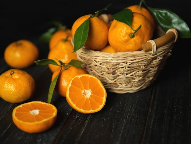 Mandarines lumineuses mûres dans un panier avec des feuilles