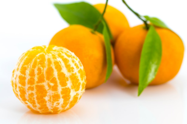 Mandarines mûres avec des feuilles gros plan sur fond blanc