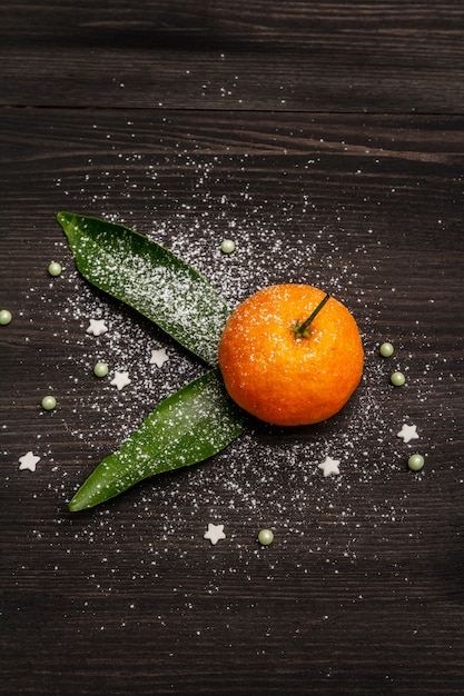 Mandarines mûres fraîches avec des feuilles et des paillettes.