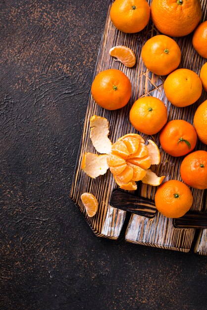 Mandarines mûres fraîches sur planche de bois