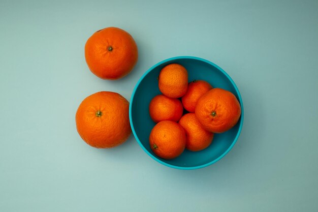 Les mandarines orange vif se trouvent sur un fond bleu