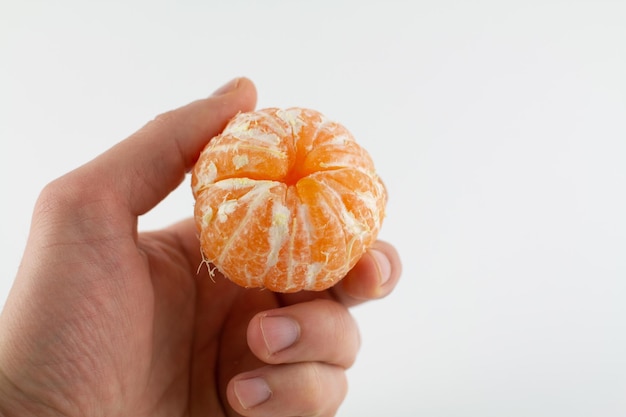 Mandarines pelées à la main sur fond blanc